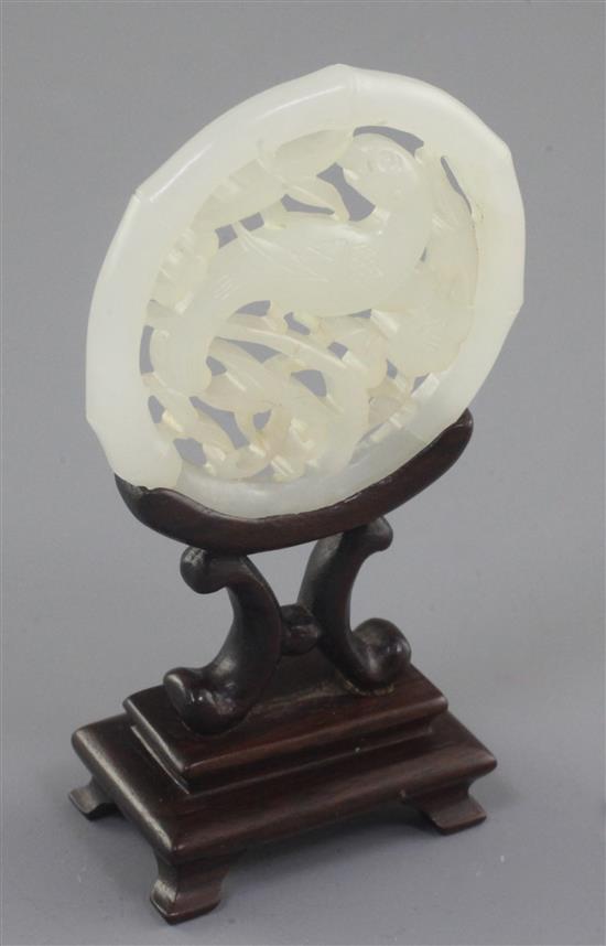 A Chinese white jade parrot disc, 19th century, 5.2cm, wood stand